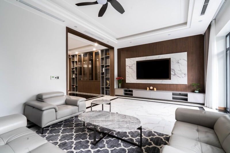 Đây là một công trình thi công hoàn thiện nội thất cho biệt thự 4 tầng tại Nghệ An. Phía đối diện bộ sofa bọc da hiện đại cao cấp là khu vực tivi. Để trang trí nội thất cho biệt thự này, Morehome sử dụng hai vật liệu là gỗ ốp tường và đá nhân tạo vân mây ốp tường.